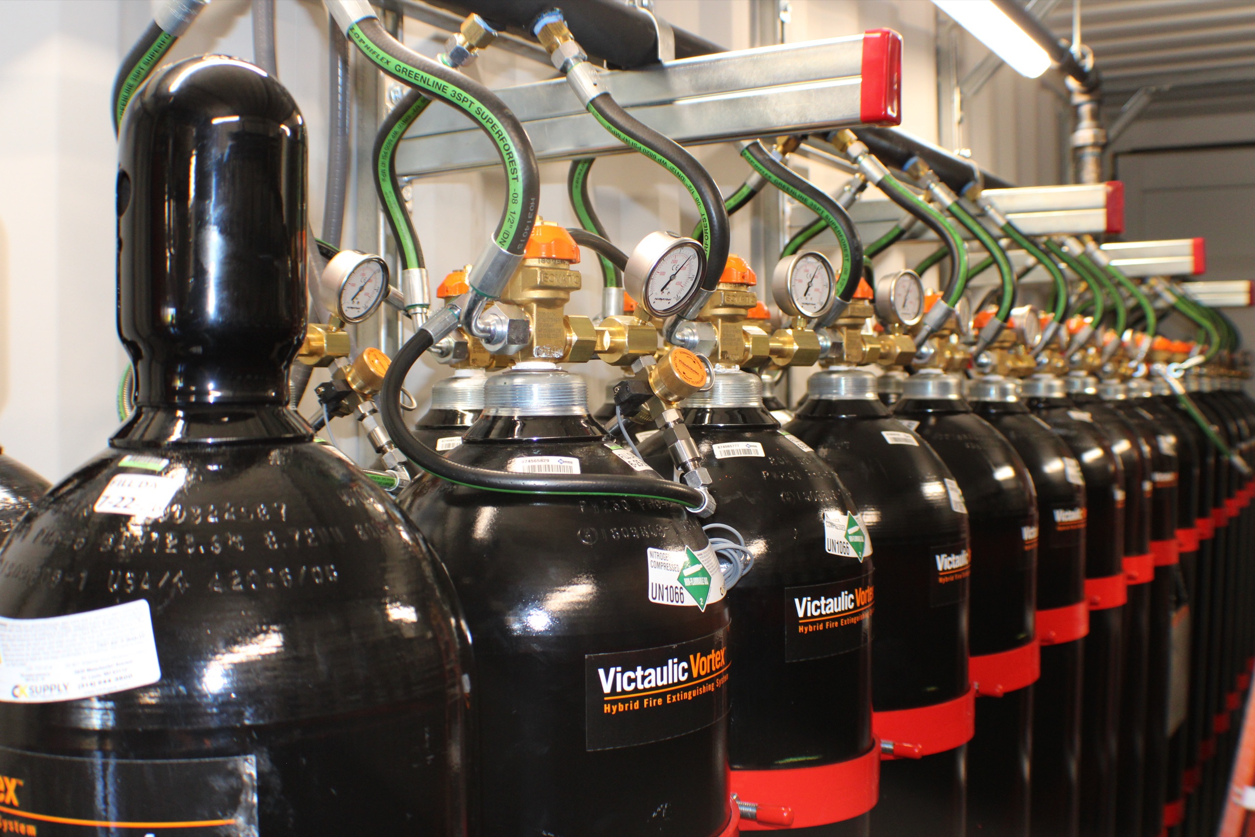Row of black clean agent cylinders with red straps
