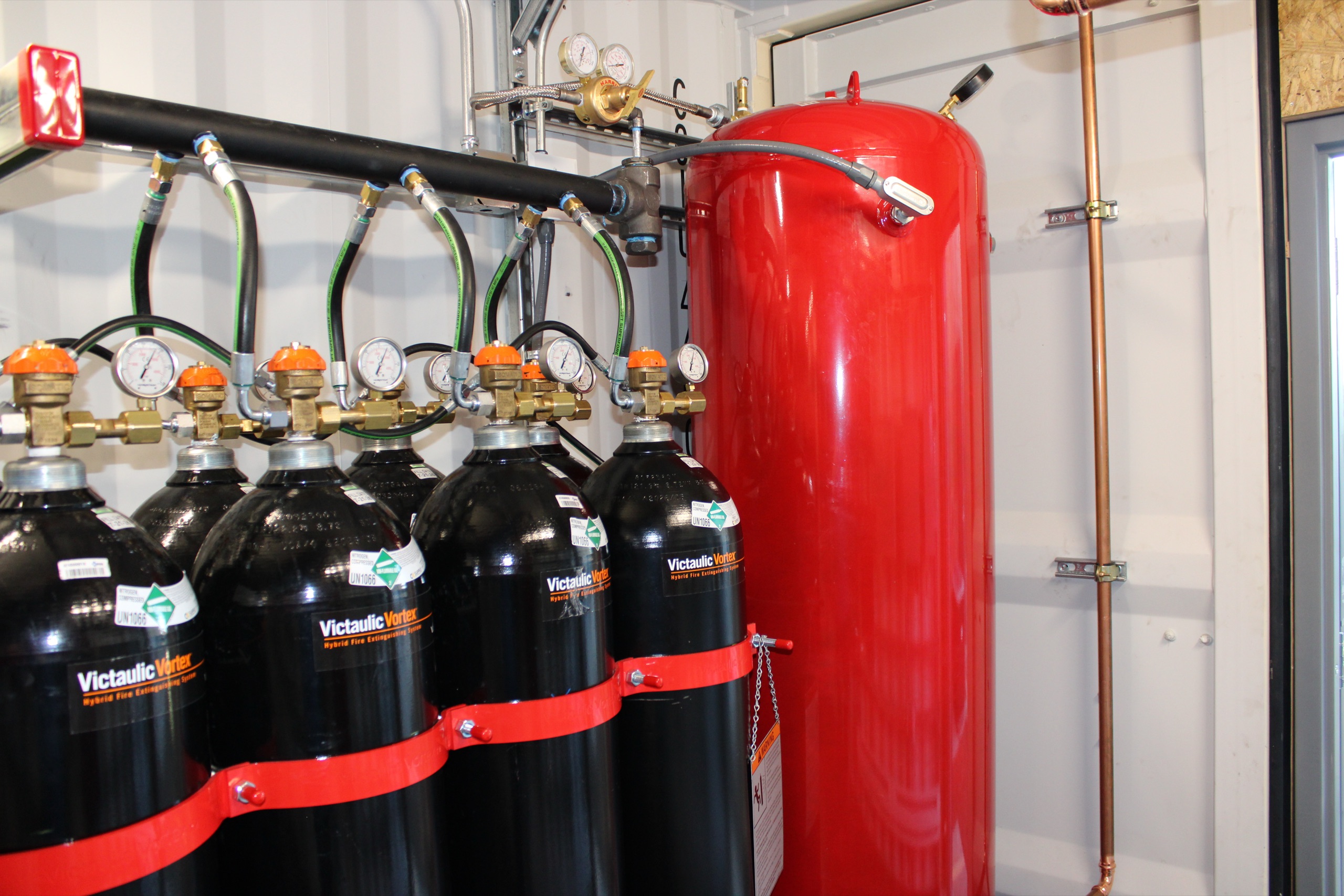 Clean agent suppression cylinders beside a red tank